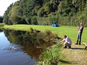 Fishery Owner Shaun Landing a Fish for Young Joe